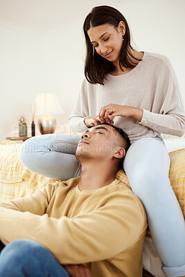 Buy stock photo Romantic, in love and relaxed couple relaxing together in a lovely, cute and peaceful home romance indoors. Loving, carefree and calm girlfriend smiling and stroking her young boyfriend's hair 