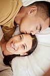 Happy, smiling and affectionate young couple in love taking a selfie together in the bed at home. Portrait of loving female taking a photo in happiness while her partner is sleeping during the day.