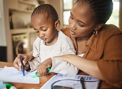 Buy stock photo African mother and small child drawing together at a desk at home. Caring, working woman making family time to play with kid. Fun and educational activities for loving mom and artistic young son.
