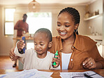 Child care, homework and play time with mother teaching, playing and helping little boy draw and color at home. Happy, smiling and loving mom and son bonding together in early childhood development 