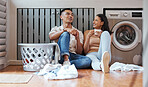 Couple, chores and laundry while doing home cleaning and feeling happy while talking and relaxing together. Boyfriend and girlfriend with healthy communication while sitting together on wash day 
