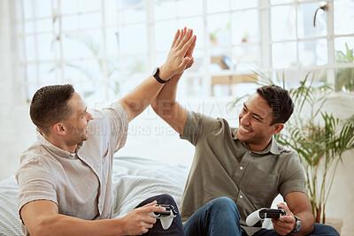 Buy stock photo Men high five, celebrate and enjoy playing video games in the sofa at home. Happy, cheerful and best friends having fun and winning while holding wireless controllers with live online game