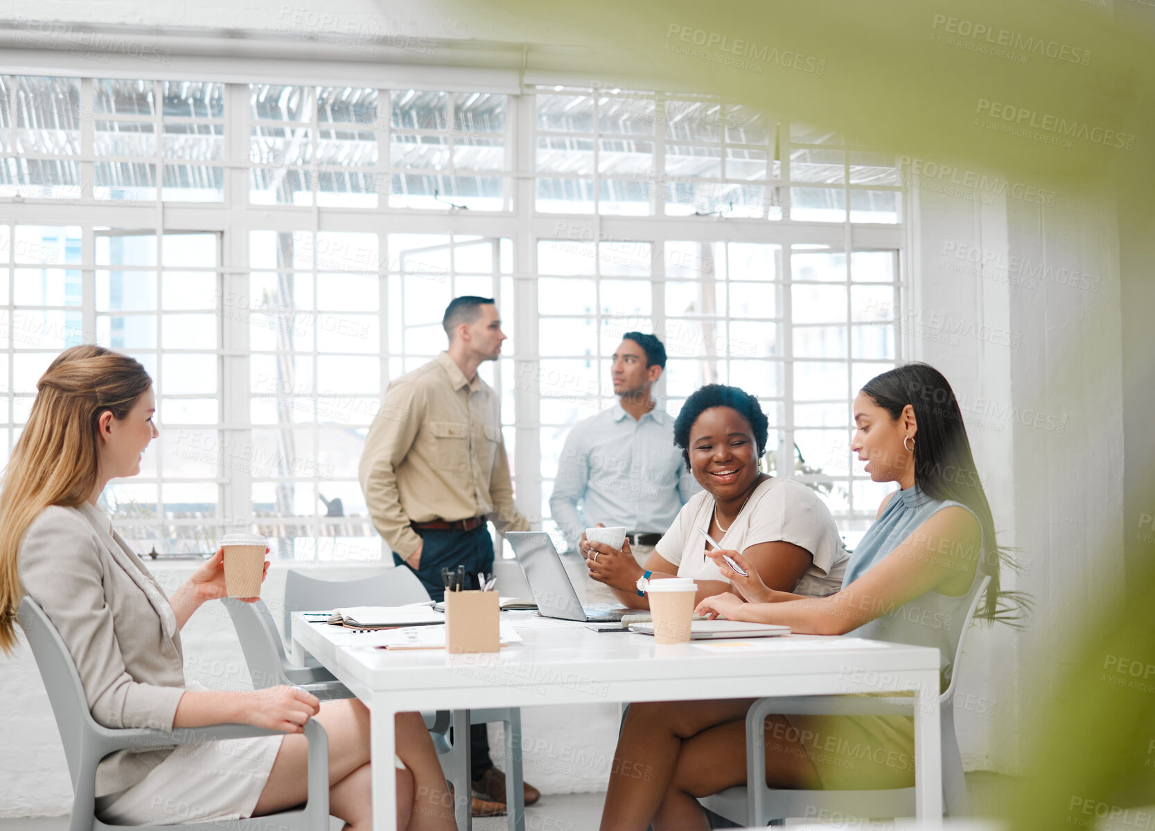 Buy stock photo Happy, smiling and friendly colleagues talking on their coffee break or meeting about the news and gossip. Young, global and diverse female employees enjoying their discussion in the staff room