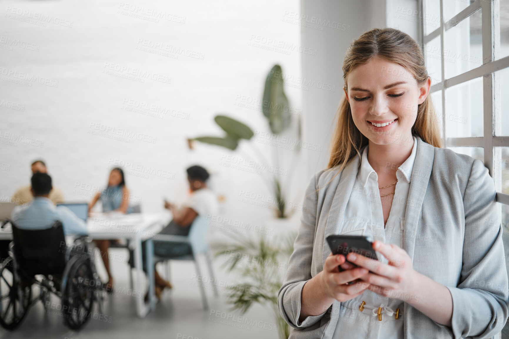 Buy stock photo Phone, networking and communication with a business woman on social media in an office for a meeting with a team in the background. Advertising, marketing and teamwork with a worker typing a message