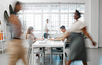 Blurred designers, marketing or freelance professionals working together in a modern office. Business men and women busy, walking and active  in a creative workplace, workstation or environment 