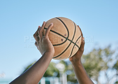 Basketball, sport and playing with a ball in the hands of a player, athlete or professional sportsperson. Closeup of a game or match outside on a court for health, recreation and fun in the sun