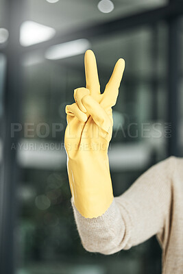 Buy stock photo Peace sign, carefree, and hand gesture while cleaning, doing chores and housework alone at home. Closeup of fingers of a cleaner counting, expressing happiness and enjoying a hygiene task