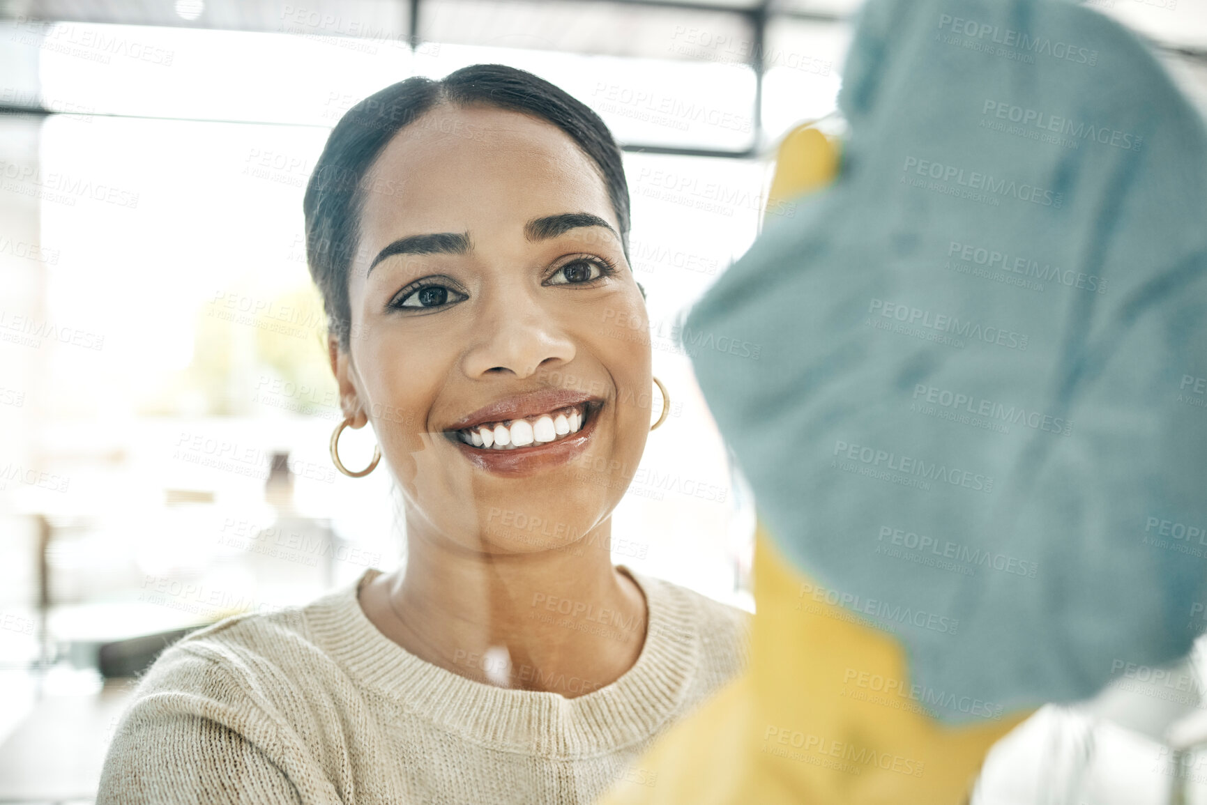 Buy stock photo Cleaning, chores and cleaner wiping windows with a soft cloth while wearing gloves in office. Smiling, young and female maid doing hygiene housekeeping. Beautiful lady keeping her home clean.