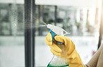 Clean, wash and day chores at home with a household hygiene spray bottle for windows inside. Closeup of cleaning job, washing and working hand with gloves spraying glass cleaner with care indoors 