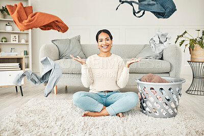 Buy stock photo Portrait of a cleaning, carefree female cleaner throwing clothing in the air. Happy, smiling and young woman doing laundry, washing clothes and sitting in a messy living room at home.