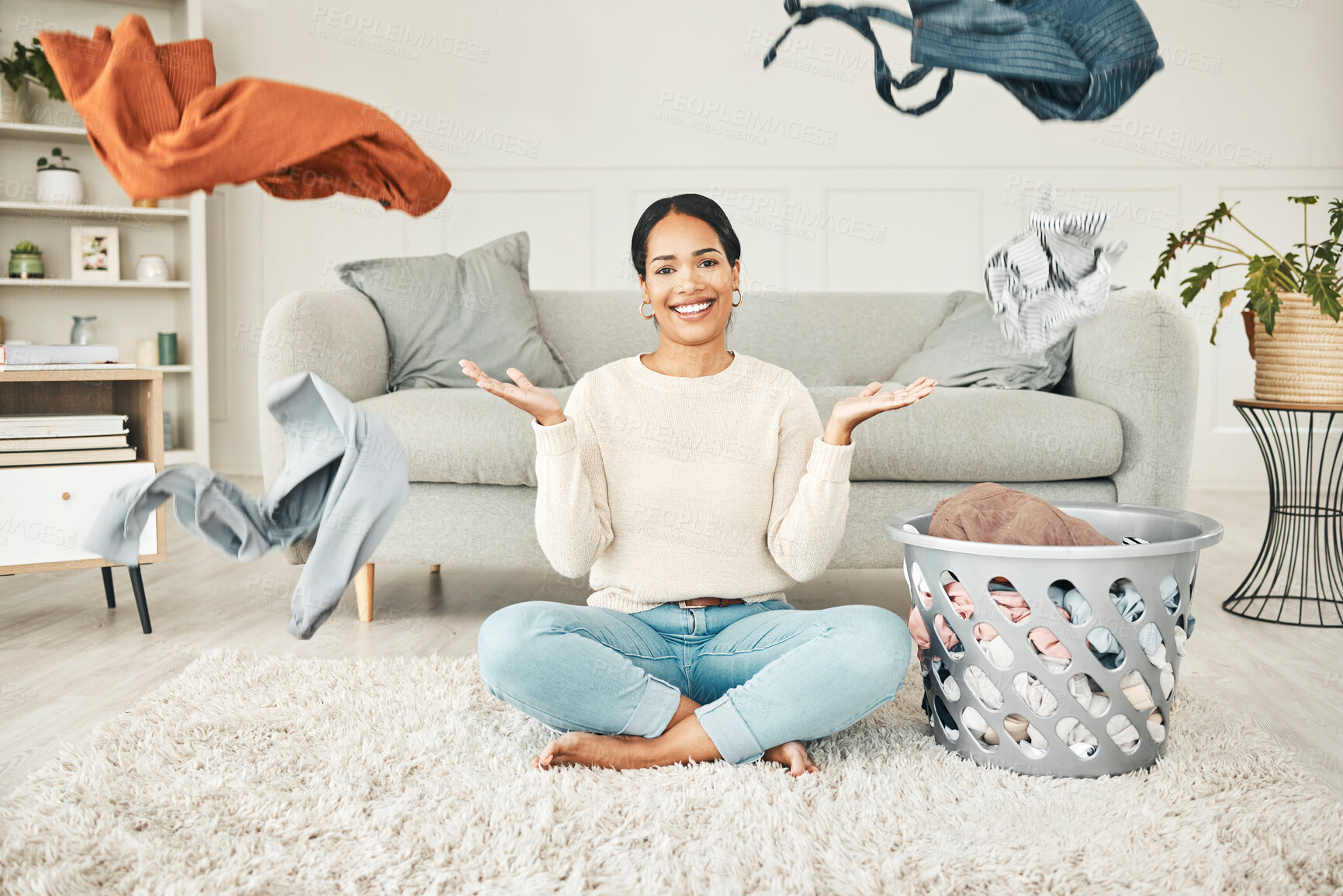 Buy stock photo Portrait of a cleaning, carefree female cleaner throwing clothing in the air. Happy, smiling and young woman doing laundry, washing clothes and sitting in a messy living room at home.