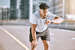 Fitness, tired and runner checking watch for running speed, pace and time in routine workout, exercise and city training. Fit, active and healthy man monitoring wellness, endurance and cardio health