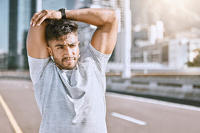 Buy stock photo Man doing warmup stretch before running in urban city street, getting ready for fitness training workout and exercise in road. Serious male athlete stretching arms before jogging and sport routine