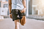 Fit, health and active runner stretching his leg before running or training in the city for a morning workout routine. Closeup of wellness male athlete or sportsman preparing for his fitness exercise