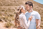 In love, hugging and bonding young couple happy, smiling on an outdoors vacation getaway. Romantic couple relax outside together embracing and loving romance, happiness and the sun on a summer day
