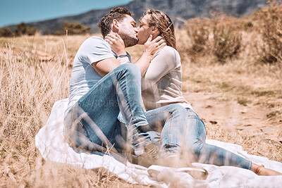 Buy stock photo Kissing, in love and young couple on picnic valentine date outdoors in sunny summer or spring. Intimate, passionate and dating romantic cute boyfriend and girlfriend in relationship together outside.