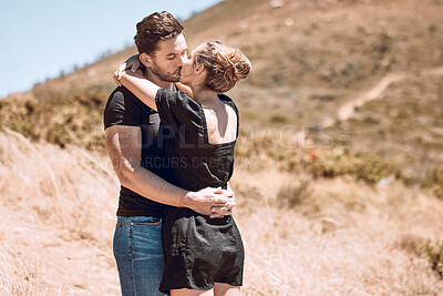 Buy stock photo Kissing, relaxed and romantic couple enjoying love, bonding and break on getaway together on a sunny day outdoors. Boyfriend and girlfriend in a loving relationship on honeymoon, holiday and date