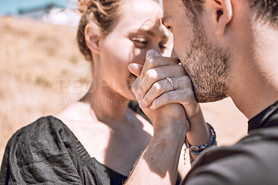 Buy stock photo Engagement, love and romance with couple proposal and save the date goal. Closeup of man bonding, holding and kissing woman's hands while feeling happy or excited with safety, security and trust ring
