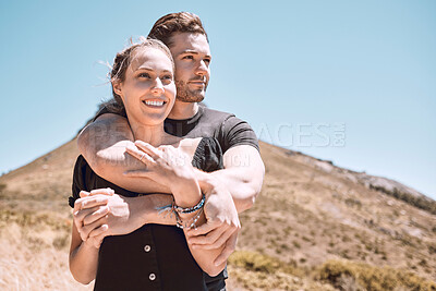 Buy stock photo Love, romance and dating with an affectionate young couple bonding while enjoying hiking, adventure and exploring together. Hugging, loving and dating with a man and woman looking at a nature view