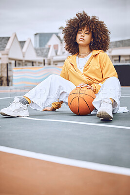 Basketball, court and sport woman portrait while sitting with ball. Stylish, edgy and afro lady looks cool in athletic clothes. Casual female model for athlete leisure and fashion clothing campaign.