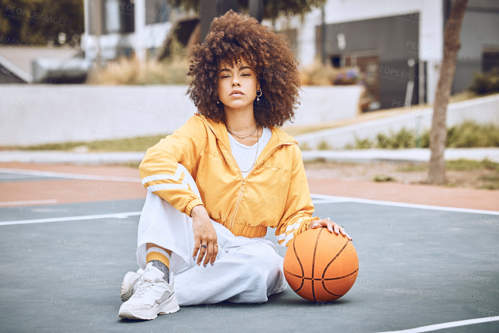 Buy stock photo Young, fashionable and beautiful black woman basketball player or athlete with afro sitting on a court ground. Portrait of cool and edgy person in a sport outfit and funky fashion clothing outdoors