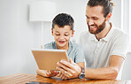 Learning, education and development with a father and son browsing online study material on a tablet at home. Young boy and his dad doing homework or studying with the internet as a resource