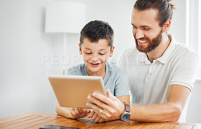 Buy stock photo Learning, education and development with a father and son browsing online study material on a tablet at home. Young boy and his dad doing homework or studying with the internet as a resource
