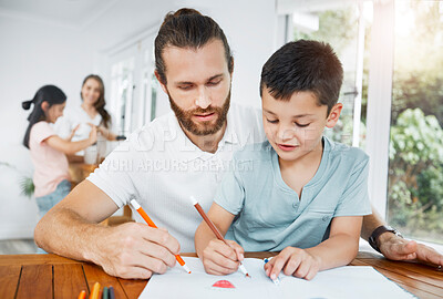 Buy stock photo Father and son bonding, drawing and learning with the family in the background at home. Little boy and his male parent coloring in and having fun while doing homework and spending time together