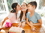Birthday party, mothers day or festive celebration with mother and kids celebrating mom with a cake and festive, fun decoration. Loving and affectionate children kissing mother showing love and joy