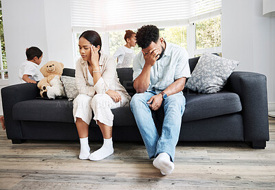 Buy stock photo Sad, unhappy and stressed parents sitting on a couch near their children at home after an argument. Frustrated, tired and annoyed mom and dad are angry at hyperactive, noisy and naughty kids