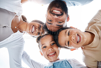 Buy stock photo Huddled family bonding, laughing and having fun while standing in a circle with heads in the middle. Below playful portrait of excited, happy and cheerful mother, father and children close together