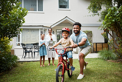 Buy stock photo Boy on bicycle learning with proud dad and happy family in their home garden outdoors. Smiling father teaching fun skill, helping and supporting his excited young son to ride, cycle and pedal a bike 