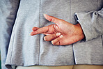 Hand gesture, sign or icon of a liar not telling the truth and being dishonest. Female waiting for good news and holding a sign. Woman crossing fingers for good luck, hope or a lie, behind her back.