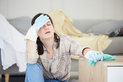 Buy stock photo Tired, stressed young woman with headache doing spring cleaning chores, sitting in her living room at home. Frustrated, overworked female is exhausted from hygienic domestic housekeeping service