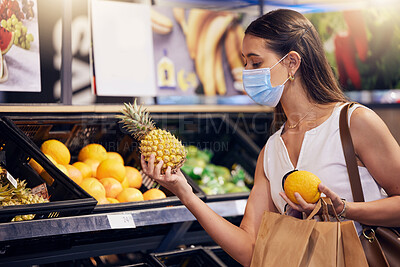 Buy stock photo Shopping, holding and looking at fruit at shop, wearing mask for safety and protecting from covid at a grocery store. Young woman buying healthy produce, choosing items and examining at market