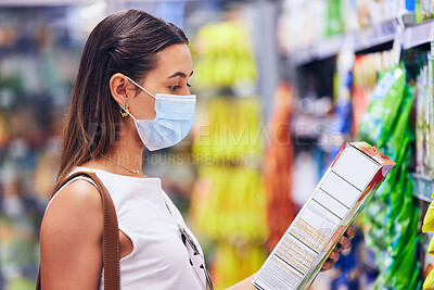 Buy stock photo Woman reading food box information or list at the grocery store, shop or supermarket. Trendy, young female shopping in covid pandemic with a mask for organic, fresh and healthy ingredients.