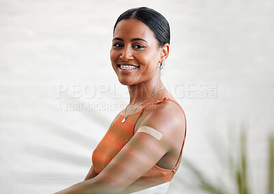 Buy stock photo Plaster, vaccinated and covid treatment on a womans arm as she's smiling, happy and proud to stay safe. Healthy female with a band aid protecting against corona virus by taking a vaccine injection