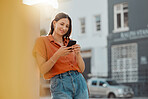 Texting on a phone, waiting for public transport and commuting in the city with a young female tourist enjoying travel and sightseeing. Looking online for places to see and visit while on holiday