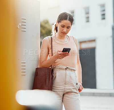 Buy stock photo Traveling businesswoman with a phone texting, browsing internet while waiting outside for transport or replying to text while commuting to work. Young worker booking online transport service in city
