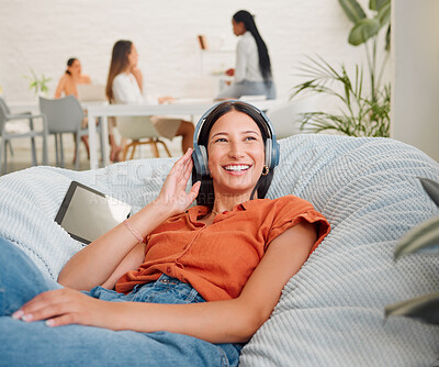 Buy stock photo Listening to music, headphones and songs from a tablet playlist for creative relaxing, enjoying and lying on office bean bag. Smiling, happy and motivated business woman on break and feeling inspired