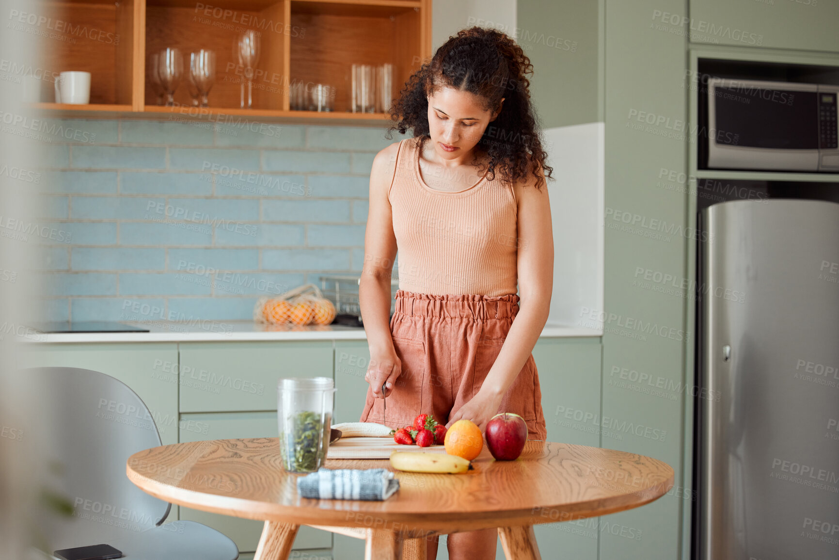 Buy stock photo Healthy, wellness lifestyle and diet meal plan preparations or woman making breakfast fruit salad or smoothie on home  kitchen table. Female preparing organic vegan food, cutting fresh ingredients.