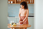 Health, meal and healthy woman alone preparing a nutritional breakfast for herself in the kitchen. Female cutting fruit to make a smoothie or salad with nutrition for an organic lifestyle at home.