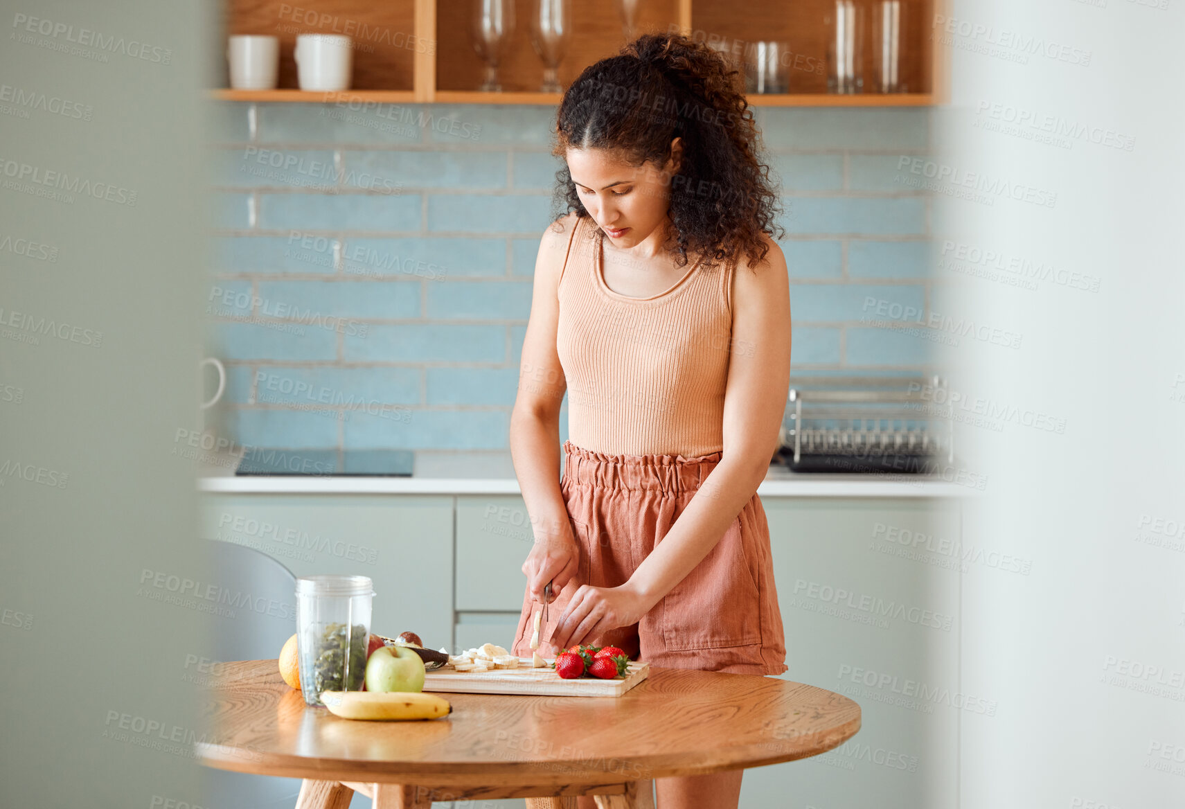 Buy stock photo Health, meal and healthy woman alone preparing a nutritional breakfast for herself in the kitchen. Female cutting fruit to make a smoothie or salad with nutrition for an organic lifestyle at home.