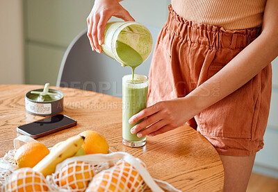 Buy stock photo Closeup of a female pouring green healthy smoothie to detox, drinking vitamins and nutrients. Woman nutritionist having a fresh fruit juice to cleanse and provide energy for healthy lifestyle

