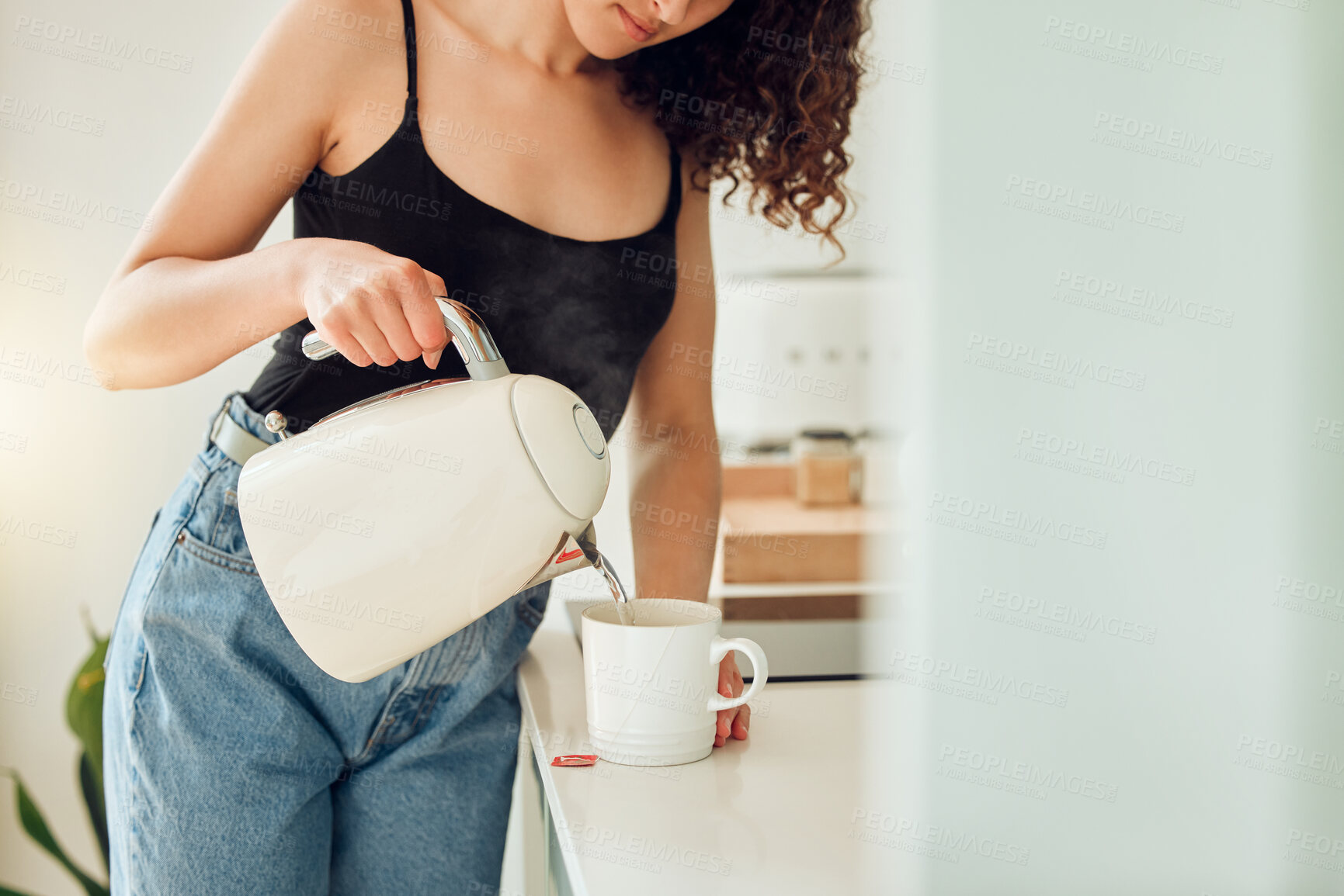 Buy stock photo Woman making a cup of tea for breakfast before starting her morning at home. Female trying a health cleanse with organic green tea, beginning a slimming detox or diet with a healthy drink