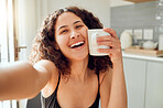 Happy, morning coffee and selfie while smiling and holding cup against her face for warmth while sitting at home. Portrait of a cheerful young woman enjoying her free time and a hot beverage 