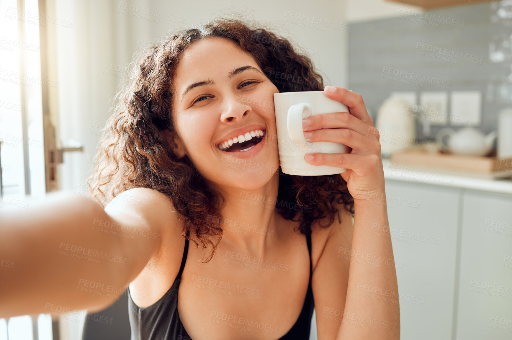 Buy stock photo Happy, morning coffee and selfie while smiling and holding cup against her face for warmth while sitting at home. Portrait of a cheerful young woman enjoying her free time and a hot beverage 