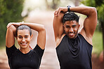 Healthy, fit and motivated couple stretching, warming up or training together in green park with bokeh background. Faces of athletic man and woman preparing for endurance workout, warmup or exercise