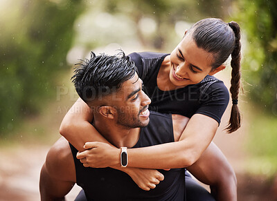 Fun couple smiling on a hike in nature, giving piggyback and enjoying a  walk in the outdoors together. Happy boyfriend carrying and holding  girlfriend, embracing and laughing while hiking for fitness