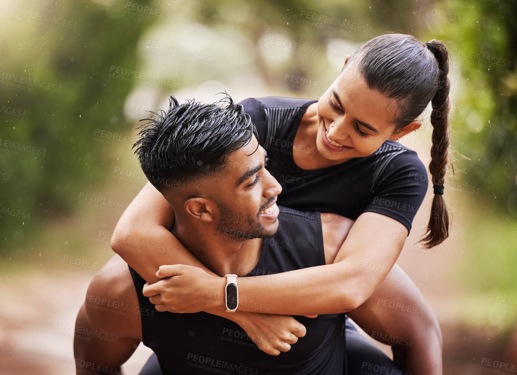 Buy stock photo Fun and playful couple playing on a hike in nature, giving piggyback and enjoying a walk in the outdoors together. Happy boyfriend carrying and holding girlfriend, embracing and laughing while hiking